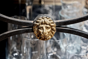 French Roger Thibier 1960's cocktail drinks console table forged metalwork aged brass gallery rails feet faux marble panels bronzed iron mask heads